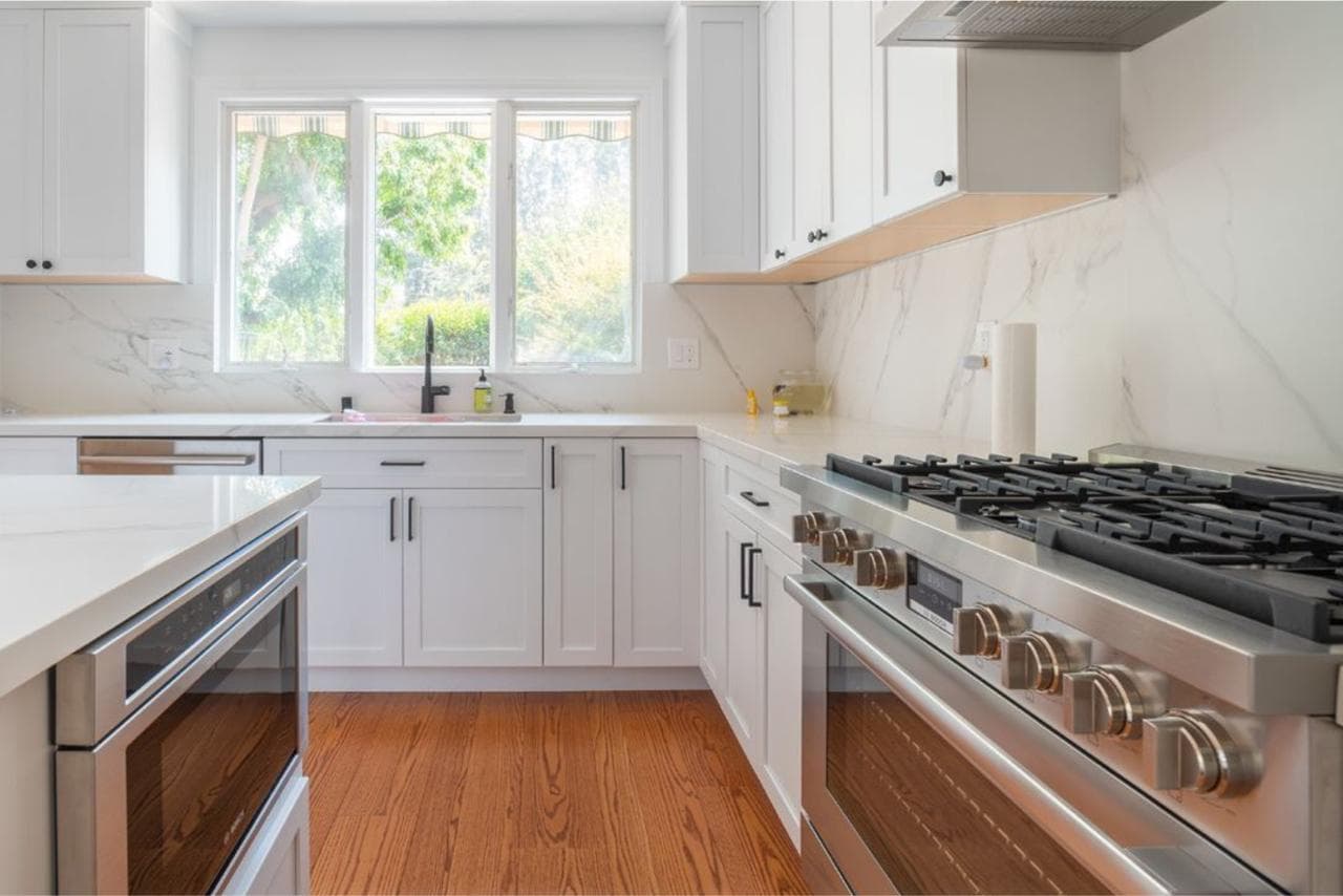 kitchen: professional gas range with marble backsplash with white quartz countertops and marble slab backsplash, by ASL Remodeling, San Mateo.